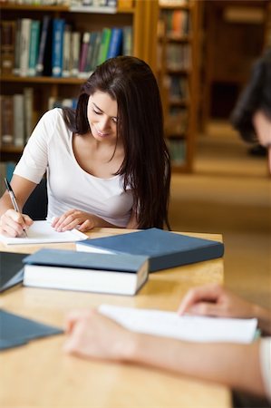 simsearch:400-05669755,k - Portrait of a student writing a paper in the library Photographie de stock - Aubaine LD & Abonnement, Code: 400-05668896