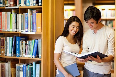 simsearch:400-05669755,k - Students looking at a book in the library Photographie de stock - Aubaine LD & Abonnement, Code: 400-05668912