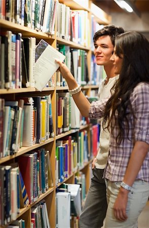simsearch:400-07337983,k - Portrait of young students choosing a book in a library Stock Photo - Budget Royalty-Free & Subscription, Code: 400-05668936