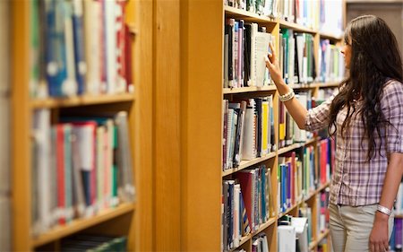 simsearch:400-07337983,k - Young woman choosing a book in a library Stock Photo - Budget Royalty-Free & Subscription, Code: 400-05668931