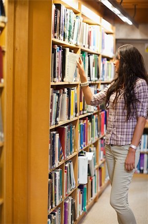 simsearch:400-05669803,k - Portrait of a young woman choosing a book in a library Stock Photo - Budget Royalty-Free & Subscription, Code: 400-05668932