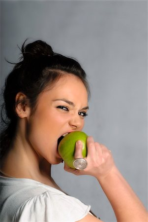 Beautiful young woman biting an apple portrait isolated Stock Photo - Budget Royalty-Free & Subscription, Code: 400-05669282