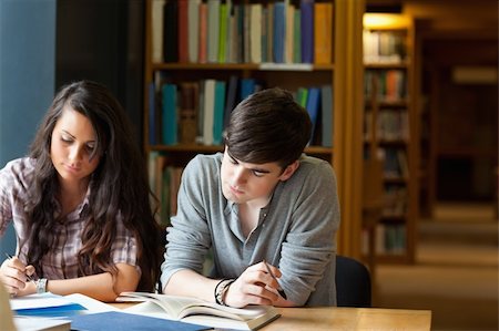 Students writing an essay in a library Stock Photo - Budget Royalty-Free & Subscription, Code: 400-05669766