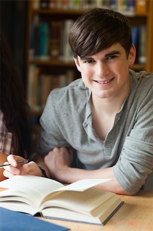 simsearch:400-05669755,k - Portrait of a smiling student in a library Photographie de stock - Aubaine LD & Abonnement, Code: 400-05669803