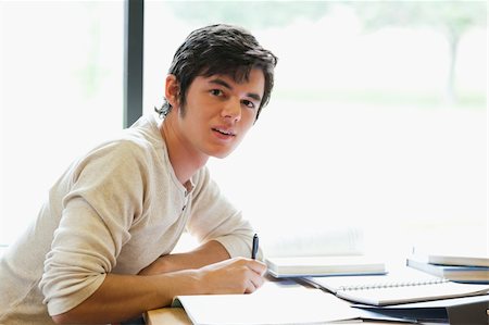 simsearch:400-05669803,k - Handsome student writing a paper in a library Stock Photo - Budget Royalty-Free & Subscription, Code: 400-05669867