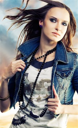 simsearch:400-05678958,k - Girl with flying hair  holding beads in jeans jacket on the abstract background Photographie de stock - Aubaine LD & Abonnement, Code: 400-05663250