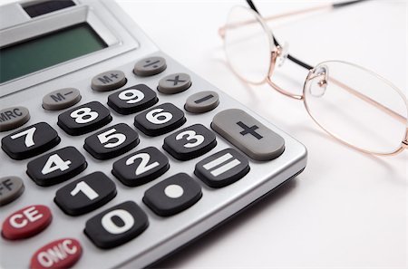 simsearch:400-08408451,k - Business background with calculator and glasses isolated in white Stock Photo - Budget Royalty-Free & Subscription, Code: 400-05663904