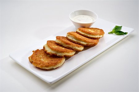 shrove tuesday - Potato pancakes served on white plate with sour cream Stock Photo - Budget Royalty-Free & Subscription, Code: 400-05674540