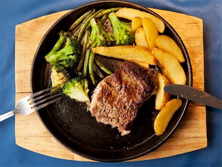 simsearch:400-04684204,k - Fried meat and potatoes on pan on blue tablecloth Photographie de stock - Aubaine LD & Abonnement, Code: 400-05674627