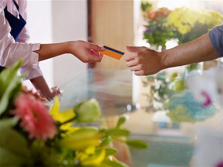 Young woman working as florist giving credit card to customer after purchase. Horizontal shape, closeup Stock Photo - Budget Royalty-Free & Subscription, Code: 400-05674623