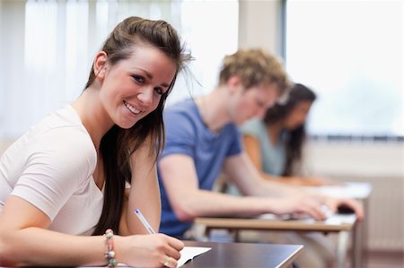 simsearch:400-05677768,k - Smiling woman writing in a classroom Stock Photo - Budget Royalty-Free & Subscription, Code: 400-05677786