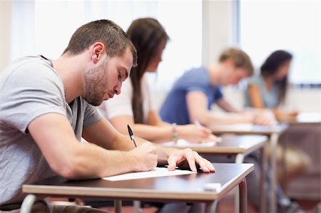 simsearch:400-05677768,k - Handsome student writing an assignment in a classroom Stock Photo - Budget Royalty-Free & Subscription, Code: 400-05677804
