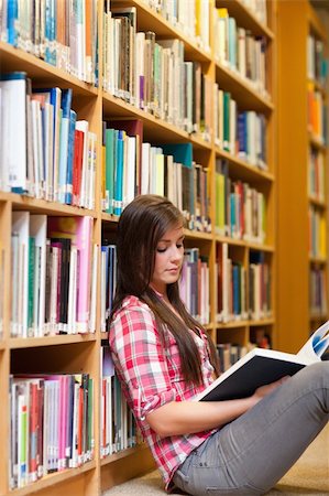 simsearch:400-05669803,k - Portrait of a young female student reading a book in a library Stock Photo - Budget Royalty-Free & Subscription, Code: 400-05678115