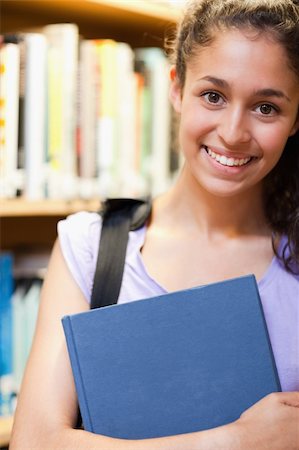 simsearch:400-05669803,k - Portrait of a happy female student holding a book in a library Stock Photo - Budget Royalty-Free & Subscription, Code: 400-05678139