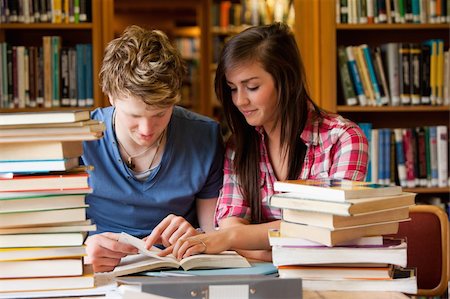simsearch:400-05669755,k - Serious students looking at a book in a library Photographie de stock - Aubaine LD & Abonnement, Code: 400-05678172