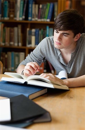 simsearch:400-05669803,k - Portrait of a handsome student writing a paper in a library Stock Photo - Budget Royalty-Free & Subscription, Code: 400-05670008