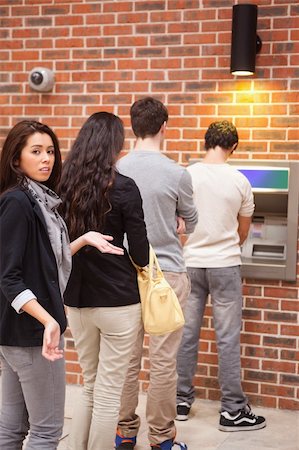 Portrait of an impatient woman queuing at an ATM Stock Photo - Budget Royalty-Free & Subscription, Code: 400-05670022