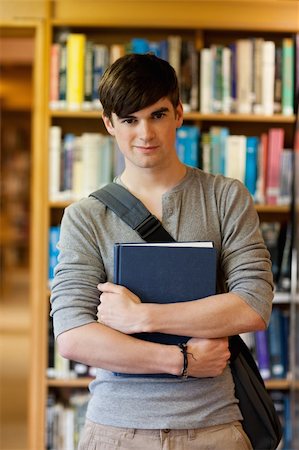 simsearch:400-05669803,k - Portrait of young student holding a book in the library Stock Photo - Budget Royalty-Free & Subscription, Code: 400-05670289