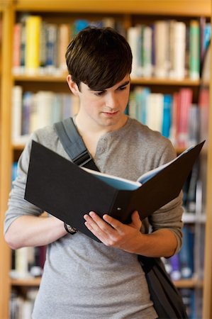 simsearch:400-05669803,k - Portrait of a smiling student looking at a binder in the library Stock Photo - Budget Royalty-Free & Subscription, Code: 400-05670293