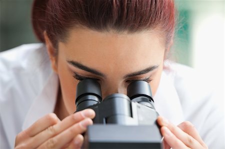 simsearch:400-05669968,k - Close up of a scientist looking into a microscope in a laboratory Stock Photo - Budget Royalty-Free & Subscription, Code: 400-05670359