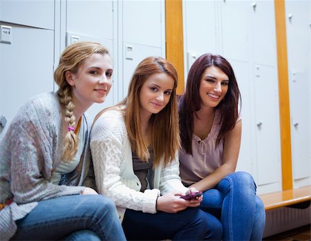 simsearch:400-05717420,k - Friends posing with a cellphone in a cloakroom Stock Photo - Budget Royalty-Free & Subscription, Code: 400-05672229