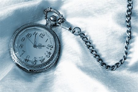 pocket watch - A pocket watch on fabric tinted in blue. Stock Photo - Budget Royalty-Free & Subscription, Code: 400-05672919