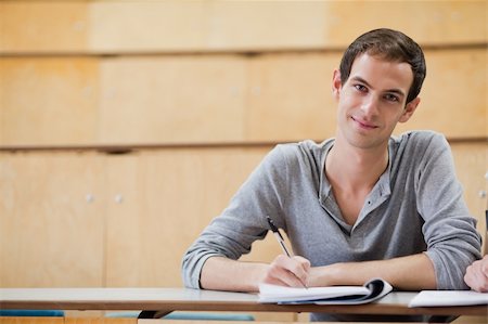simsearch:400-05677768,k - Portrait of a male student writing on a notepad in an amphitheater Stock Photo - Budget Royalty-Free & Subscription, Code: 400-05684395