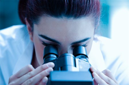 simsearch:400-05669968,k - Young scientist looking through a microscope in a laboratory Stock Photo - Budget Royalty-Free & Subscription, Code: 400-05684513