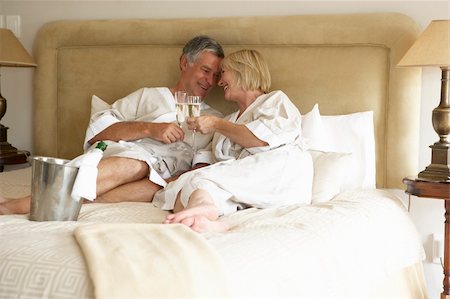 simsearch:400-05686653,k - Middle Aged Couple Enjoying Champagne In Bedroom Stock Photo - Budget Royalty-Free & Subscription, Code: 400-05686644