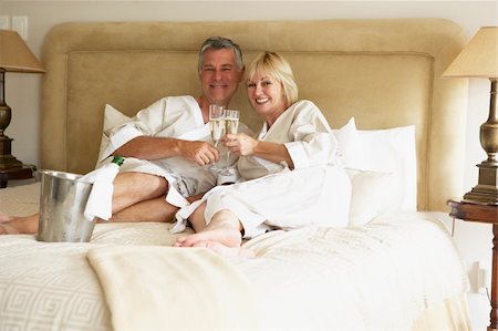 simsearch:400-05686653,k - Middle Aged Couple Enjoying Champagne In Bedroom Stock Photo - Budget Royalty-Free & Subscription, Code: 400-05686645