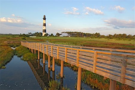 Wooden walkway from a viewpoint in the marsh leads to the Bodie Island lighthouse on the outer banks of North Carolina against a blue sky and white clouds Stock Photo - Budget Royalty-Free & Subscription, Code: 400-05680874