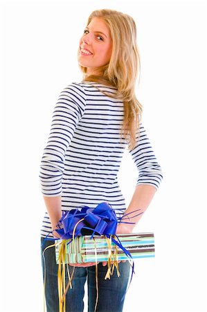 simsearch:400-05888428,k - Smiling teen girl hiding present behind back isolated on white Stock Photo - Budget Royalty-Free & Subscription, Code: 400-05692916