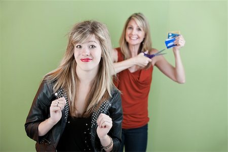 simsearch:400-05918419,k - Happy mom gestures to destroy daughter's credit cards over green background Stock Photo - Budget Royalty-Free & Subscription, Code: 400-05706836