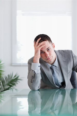 simsearch:400-05709555,k - Close up of disappointed businessman sitting behind a table Stock Photo - Budget Royalty-Free & Subscription, Code: 400-05709562