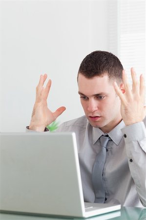 simsearch:400-05709564,k - Close up of unhappy young businessman having problems with his laptop Stock Photo - Budget Royalty-Free & Subscription, Code: 400-05709641