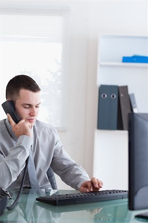 simsearch:400-05710264,k - Businessman listening to caller while typing Stock Photo - Budget Royalty-Free & Subscription, Code: 400-05709694