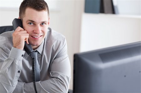 simsearch:400-05710264,k - Smiling young businessman listening to the thelephone Stock Photo - Budget Royalty-Free & Subscription, Code: 400-05709703
