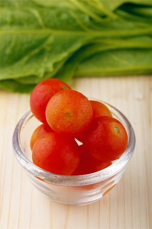 simsearch:400-04393672,k - Fresh tomatoes in a bowl and spinach leaves in the background Stock Photo - Budget Royalty-Free & Subscription, Code: 400-05702223