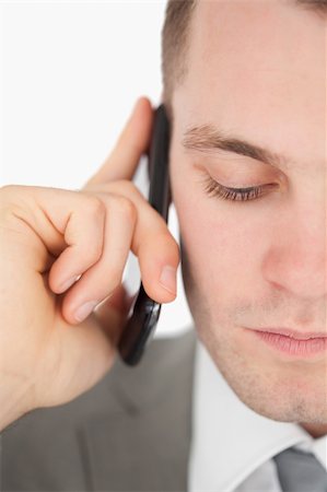 Close up of a sad businessman making a phone call against a white background Stock Photo - Budget Royalty-Free & Subscription, Code: 400-05715199