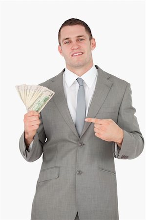 simsearch:400-05715208,k - Portrait of a businessman pointing at a wad of cash against a white background Stock Photo - Budget Royalty-Free & Subscription, Code: 400-05715212