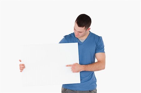 empty billboard advertising - Young man pointing at a blank panel against a white background Stock Photo - Budget Royalty-Free & Subscription, Code: 400-05715309