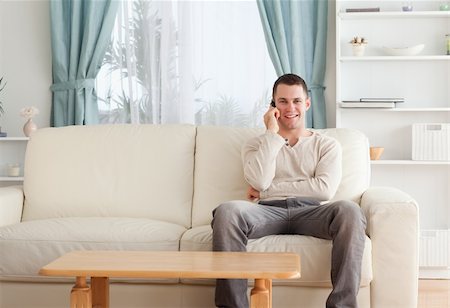 simsearch:400-04212823,k - Man on the phone while sitting on his couch against a white background Stock Photo - Budget Royalty-Free & Subscription, Code: 400-05715317