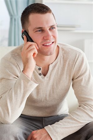 simsearch:400-04212823,k - Portrait of a man making a phone call while sitting on a sofa in his living room Stock Photo - Budget Royalty-Free & Subscription, Code: 400-05715326