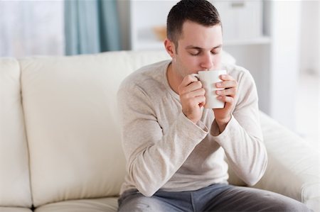 Good looking man having a tea in his living room Stock Photo - Budget Royalty-Free & Subscription, Code: 400-05715375