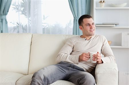 Attractive man having a coffee in his living room Stock Photo - Budget Royalty-Free & Subscription, Code: 400-05715381