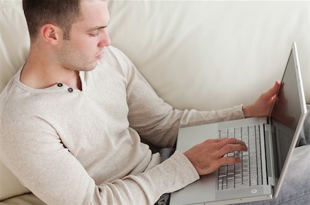 simsearch:400-04412244,k - Good looking man relaxing with a laptop in his living room Stock Photo - Budget Royalty-Free & Subscription, Code: 400-05715587