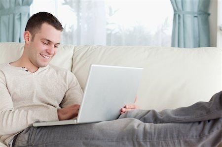 simsearch:400-04412244,k - Man relaxing with a notebook in his living room Stock Photo - Budget Royalty-Free & Subscription, Code: 400-05715590