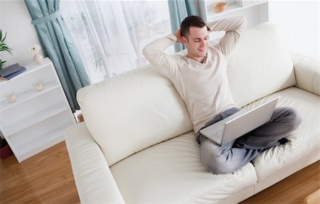 simsearch:400-04412244,k - Serene man using a notebook in his living room Stock Photo - Budget Royalty-Free & Subscription, Code: 400-05715600