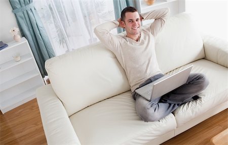 simsearch:400-04412244,k - Man enjoying using a notebook in his living room Stock Photo - Budget Royalty-Free & Subscription, Code: 400-05715601