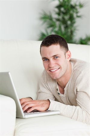 simsearch:400-04412244,k - Portrait of a man lying on a sofa with a laptop in his living room Stock Photo - Budget Royalty-Free & Subscription, Code: 400-05715656